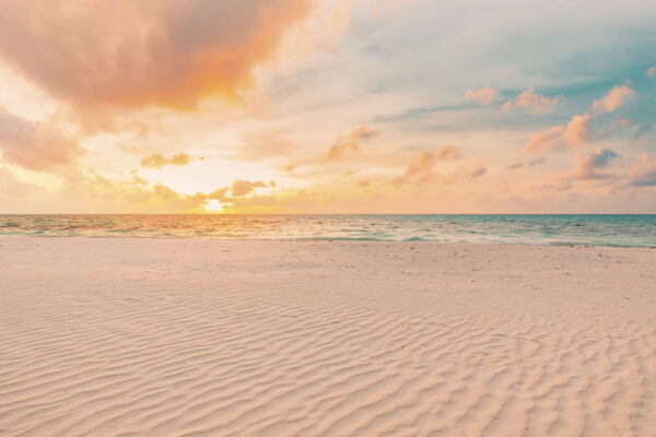 Uma praia de areia com ondas e um pôr do sol Uma praia de areia com ondas e um pôr do sol