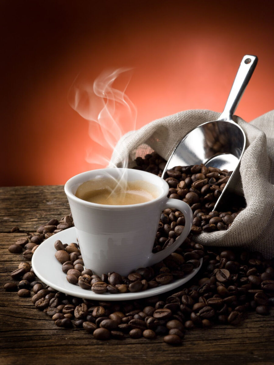 Chávena de café com vapor e grãos de café
