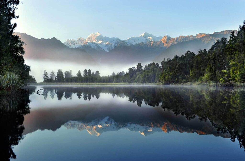 Lago com árvores e montanhas ao fundo Lago com árvores e montanhas ao fundo