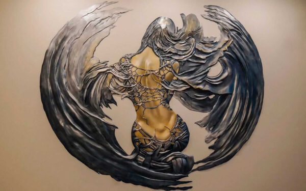 Escultura metálica de uma mulher com asas Escultura metálica de uma mulher com asas