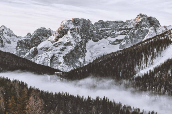 Cordilheira de neve com árvores e um edifício Cordilheira de neve com árvores e um edifício
