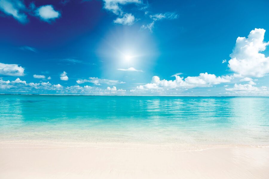 Céu azul com nuvens e uma praia de areia