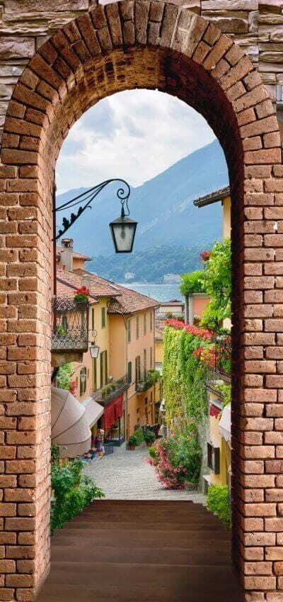 Arco de tijolo com um candeeiro de rua e vista para uma cidade