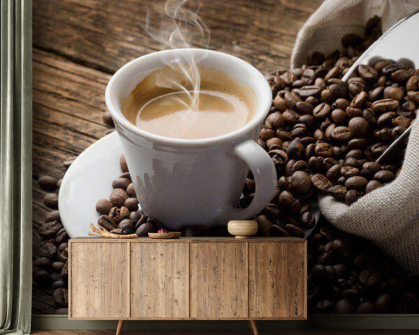 Chávena de café num pires com grãos de café Chávena de café num pires com grãos de café
