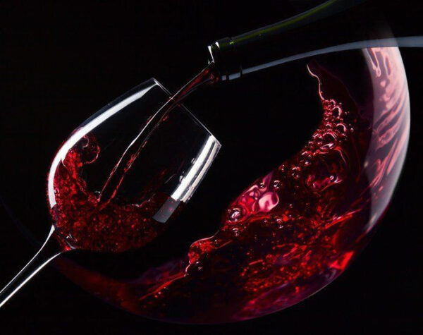 Copo de vinho tinto a ser servido Copo de vinho tinto a ser servido