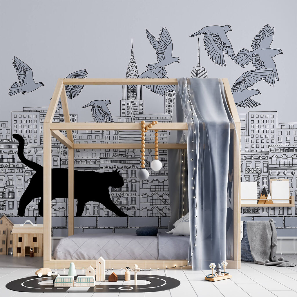 Gato a caminhar numa parede com pássaros a voar no céu